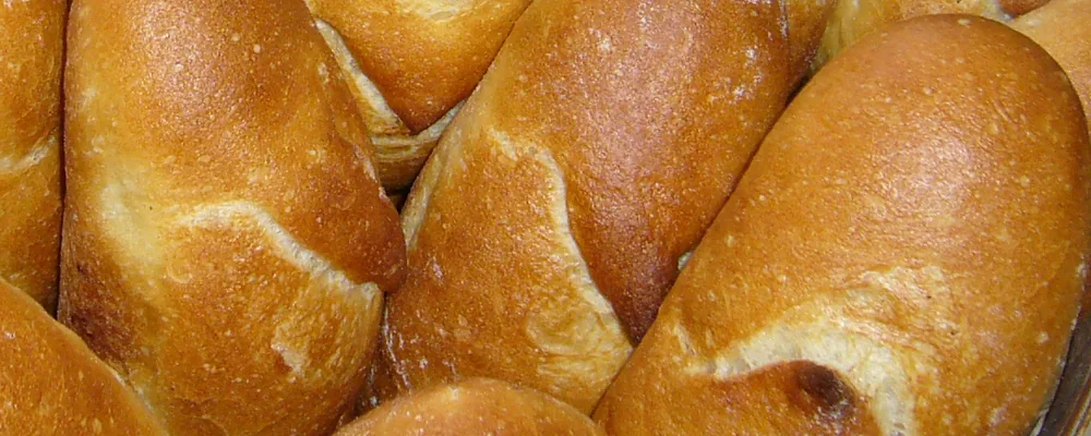 lisztes munkalap és sodrófával nyújtott zsemletészta